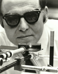 A man in sunglasses looking at optical apparatus