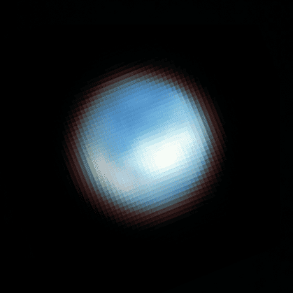 Image of Europa, which appears as a round, bluish object with a white blotch near the centre