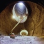 The empty tunnel excavated for the Superconducting Super Collider, with machinery and people standing around inside it