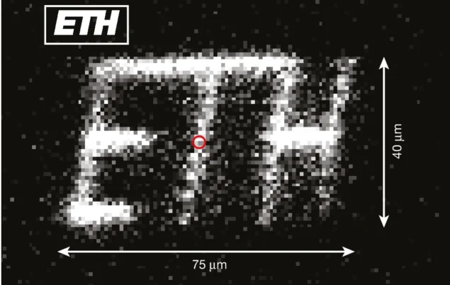 Imagen en blanco y negro que muestra las letras ETH formadas a partir de muchos puntos de luz individuales.
